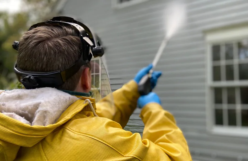 Pressure washing the exterior siding of a home